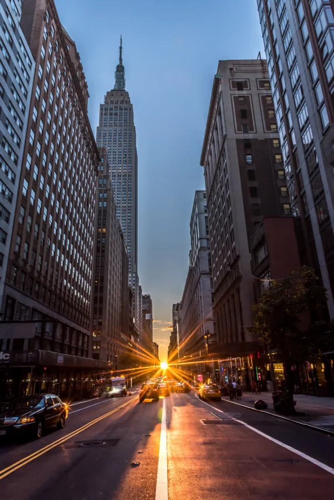 Street-level view of Midtown Manhattan with the Empire State Building at sunset, reflecting vibrant urban infrastructure and long-term real estate growth.