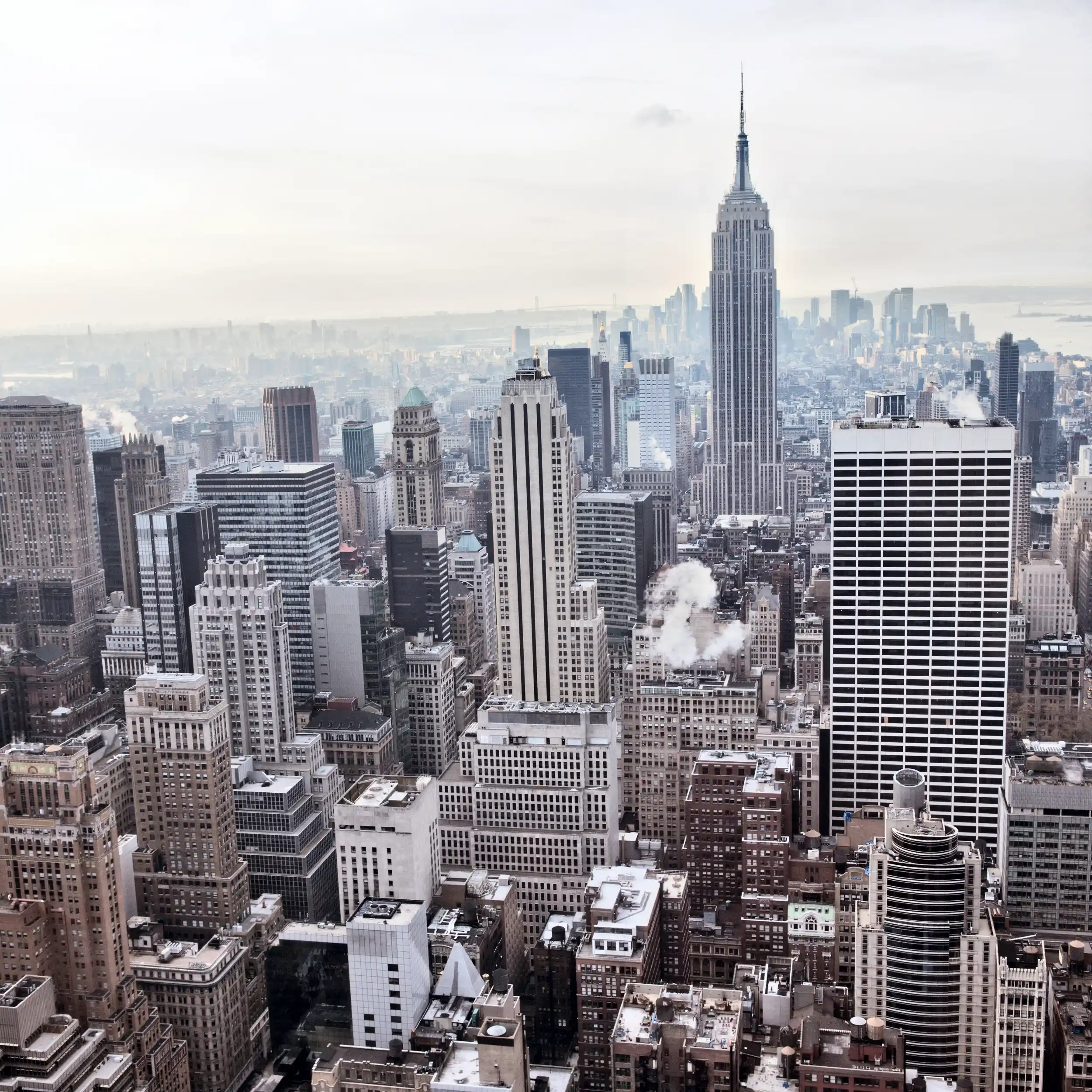 Aerial view of Midtown Manhattan skyline with the Empire State Building, representing dense urban real estate and institutional investment opportunities.